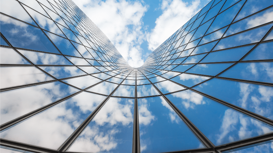Blue sky and white clouds reflecting on glass building