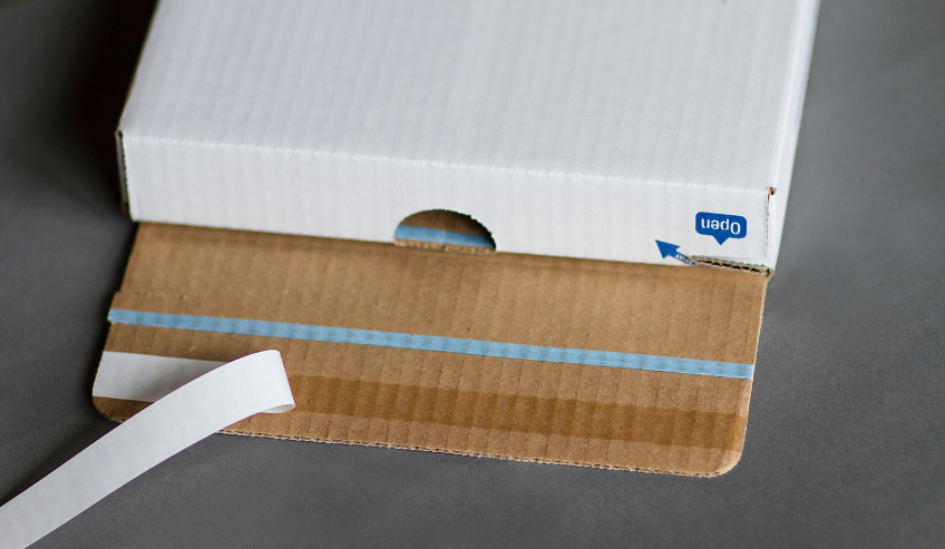 Double sided tape applied to opening of a white box