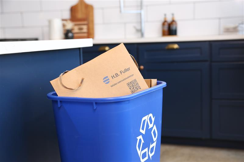 Brown bag in blue recycle bin placed in the kitchen