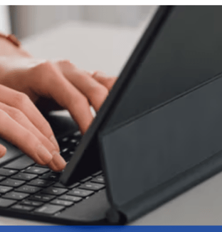 Person typing on keyboard attached to a tablet case